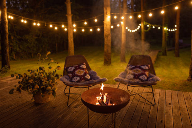 Rustic fire pit area on a wooden deck with string lights for ambiance